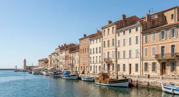 Photographie de la ville de Sète prise depuis le port ou la mer, montrant les façades colorées des immeubles résidentiels typiques de la cité côtière, avec les bâtiments et l'architecture locale représentative du tissu urbain où intervient l'entreprise de plâtrerie et rénovation. L'image doit capturer l'identité visuelle distinctive de Sète sans texte, logo ou filigrane visible.